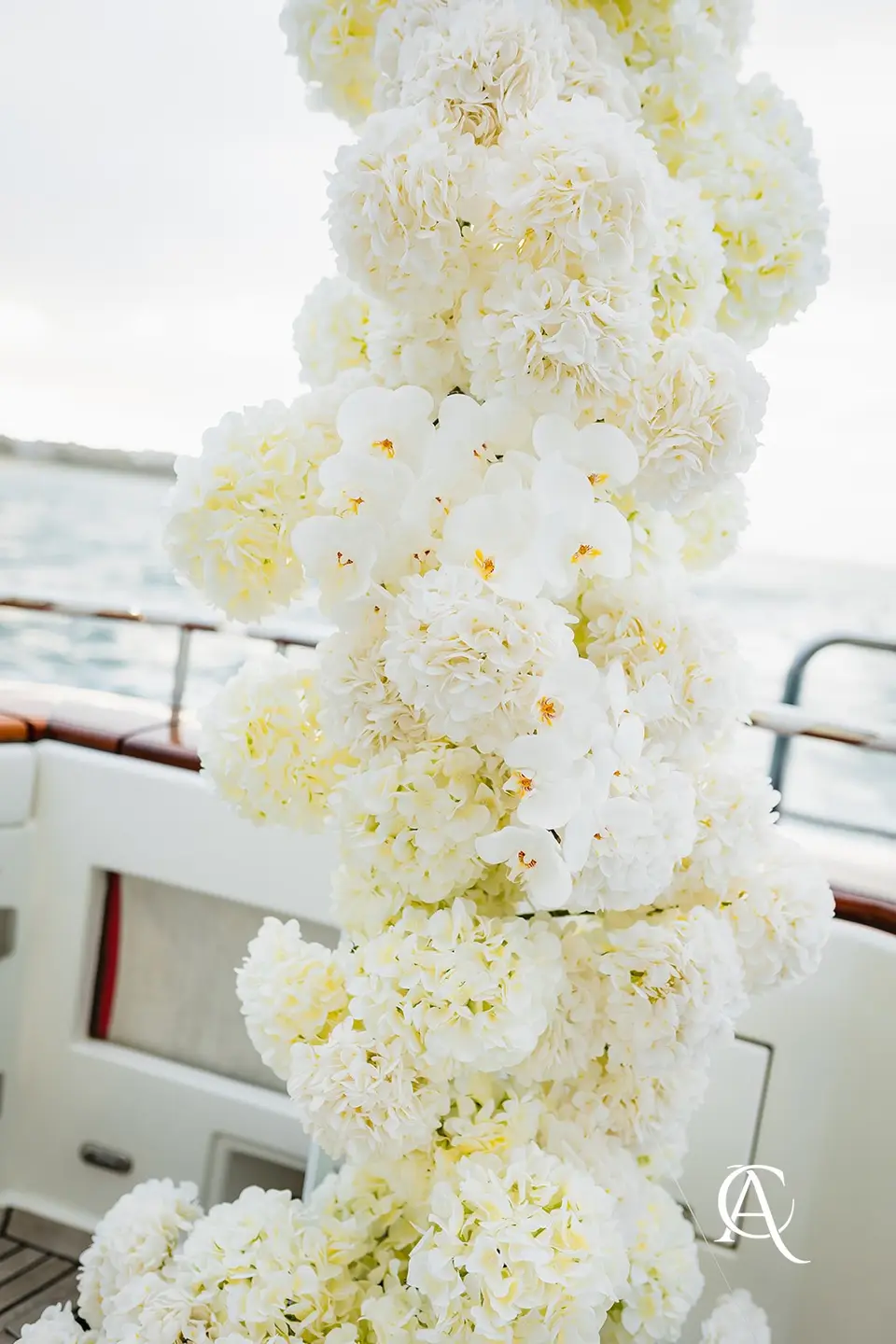Detail of white hydrangea and phalaenopsis orchids woven together in a ceremony column on a yacht